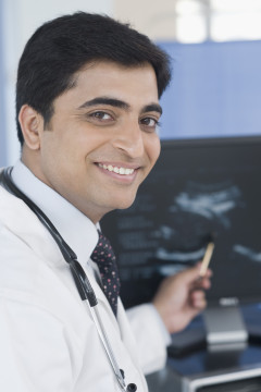 Male doctor examining ultrasound and smiling